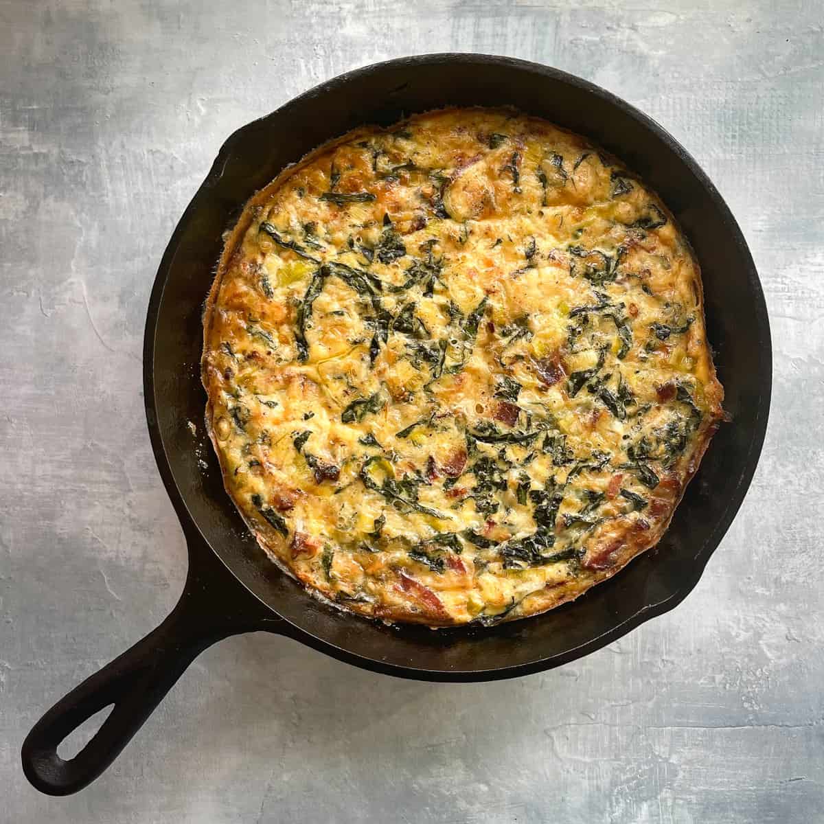 baked bacon kale and leek frittata in the cast iron pan.