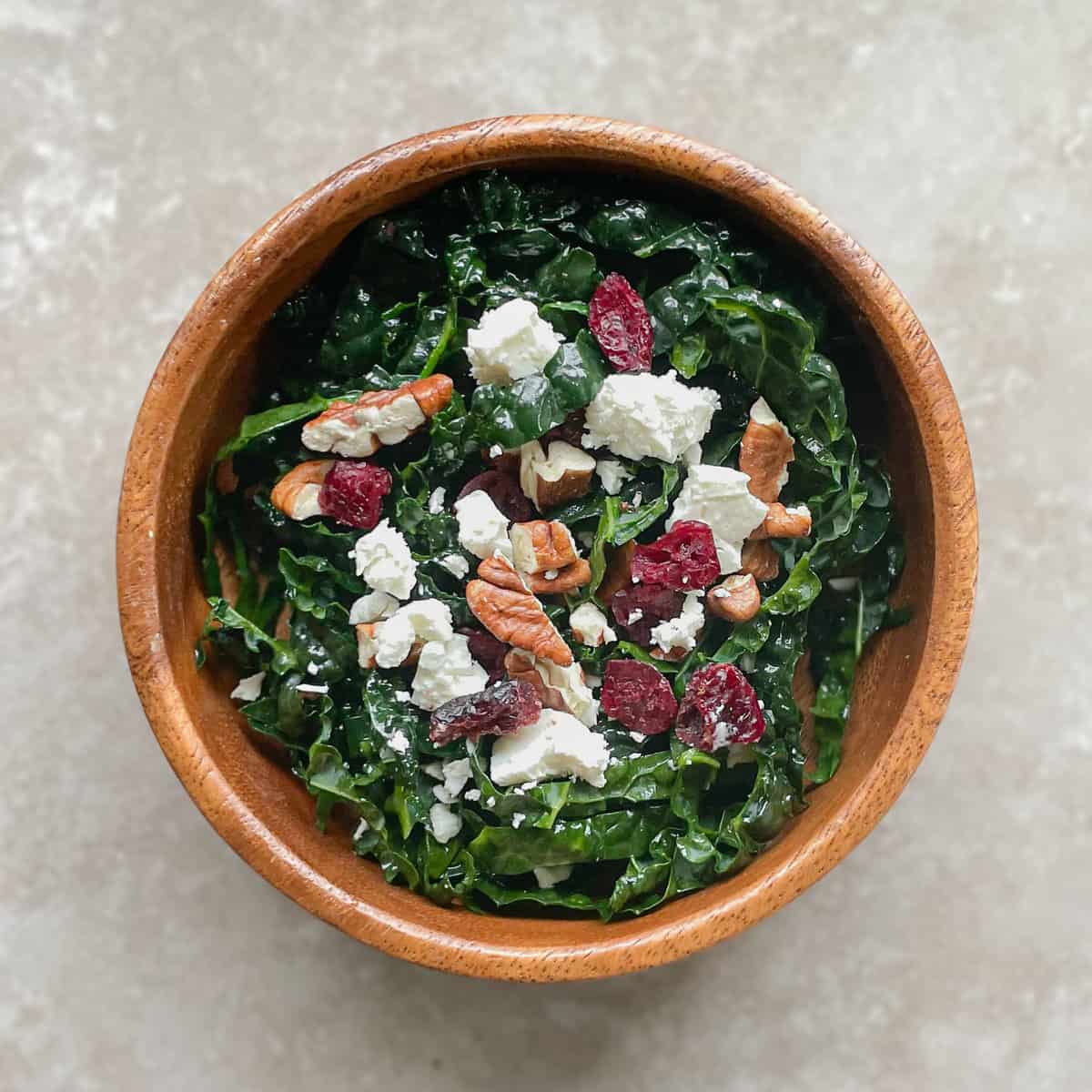 salad bowl with shredded kale, cranberries, pecans, and feta.