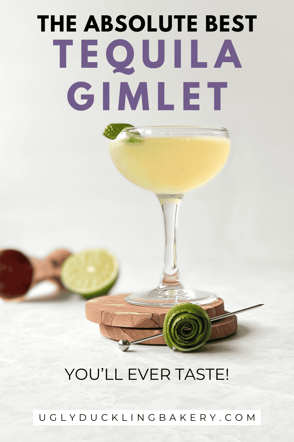 coupe with tequila gimlet garnished with lime on two coasters next to a lime wheel, lime half, and jigger. The title says the absolute best tequila gimlet. The website ugly duckling bakery dot com is at the bottom.