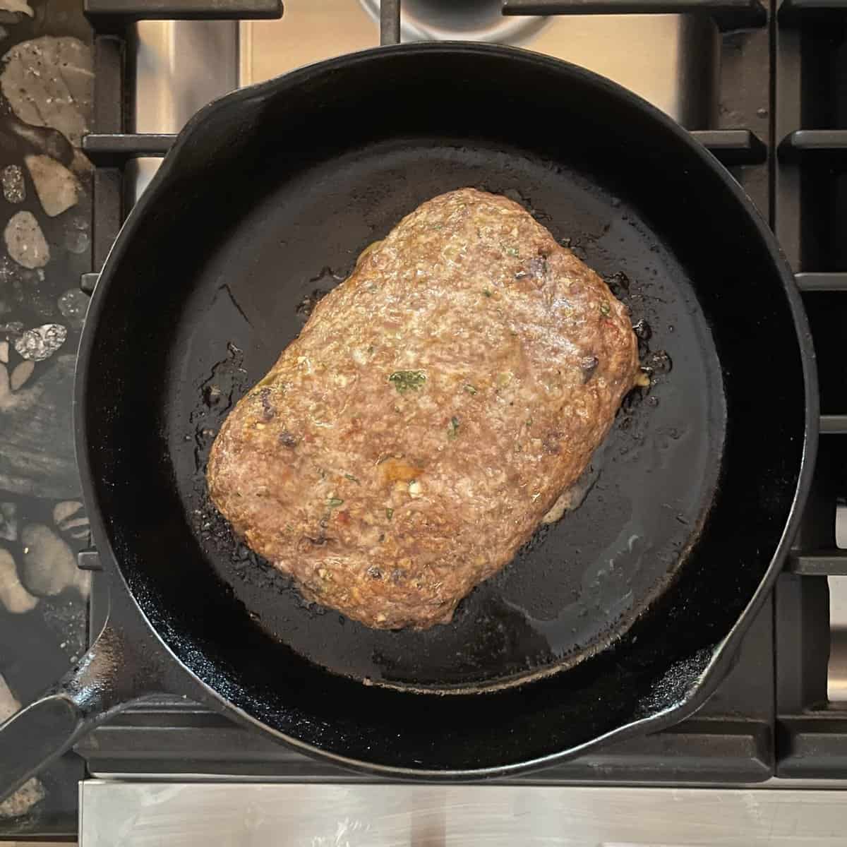 cooked meatloaf in a cast iron skillet.
