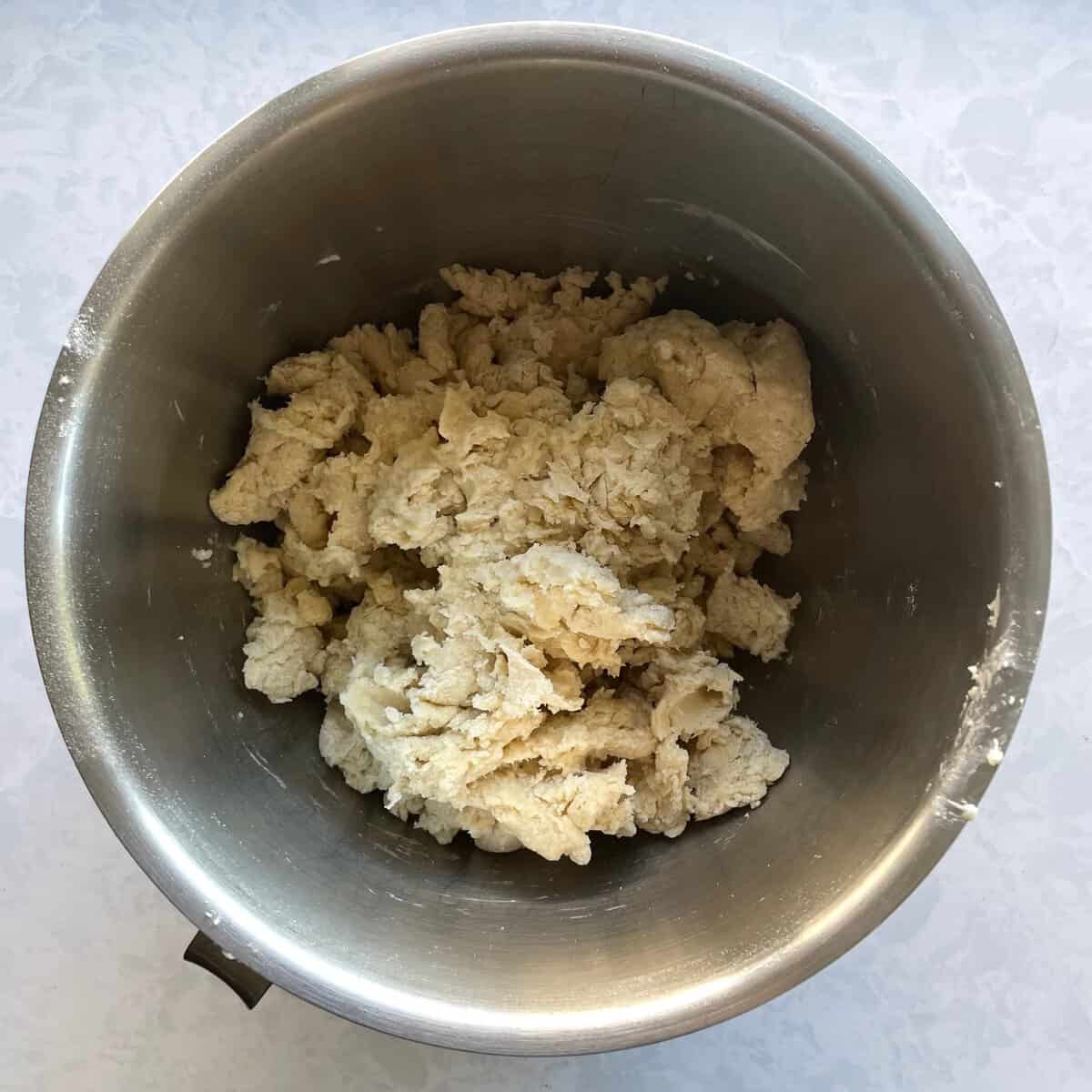 shaggy pale dough in a mixing bowl.