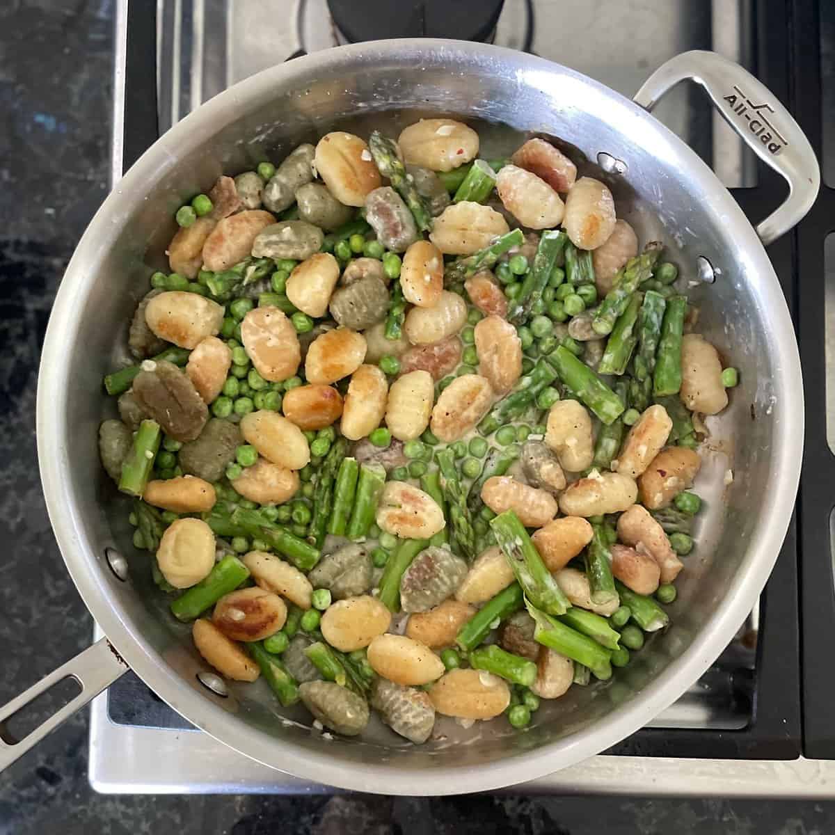 lightly browned gnocchi and chopped asparagus and peas in a large frying pan.