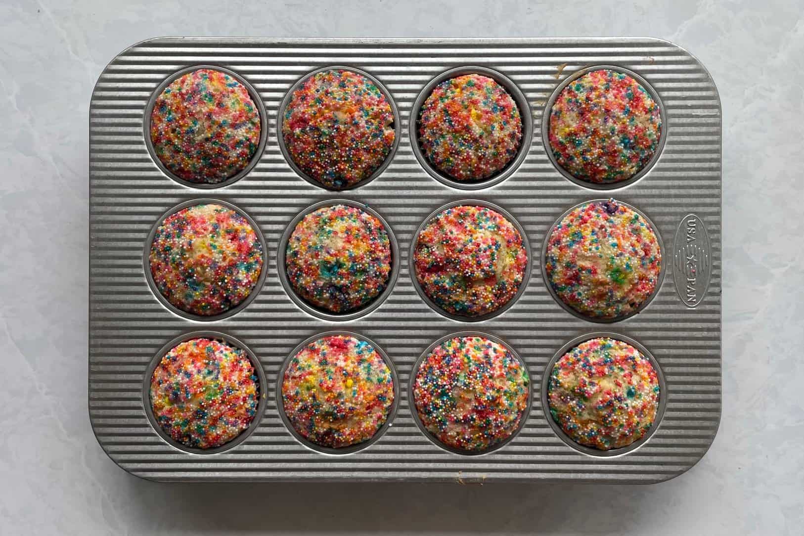 twelve baked funfetti muffins in the muffin tin.