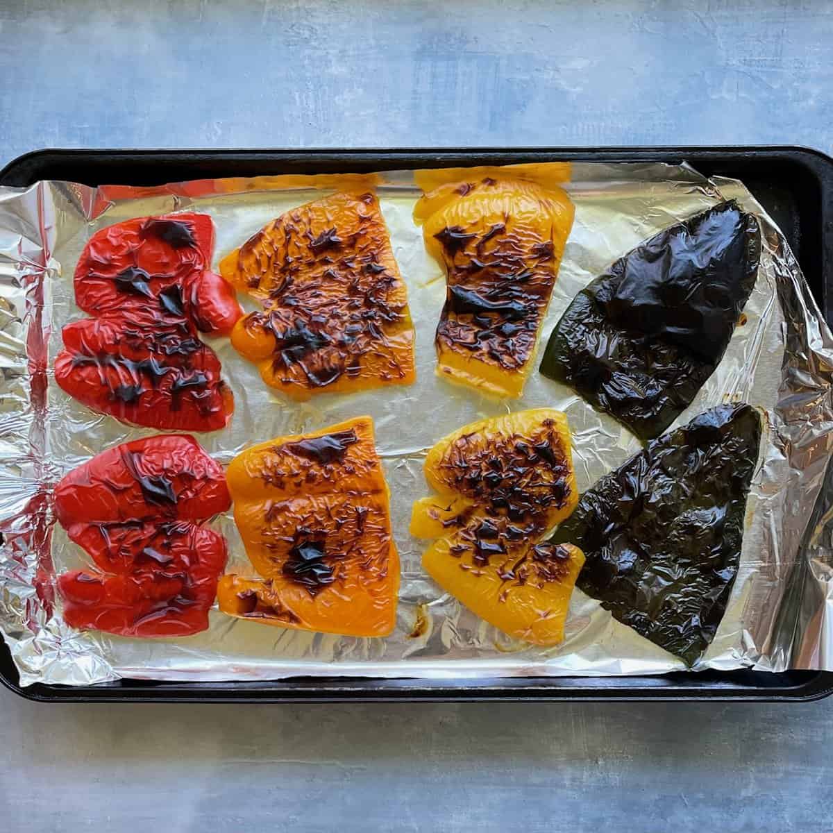 red, orange, and yellow peppers and a poblano, cut in half and placed on a foil-lined sheet and blackened under a broiler.