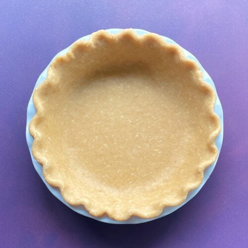 cheddar cheese pie crust in a pie pan with fluted edges.