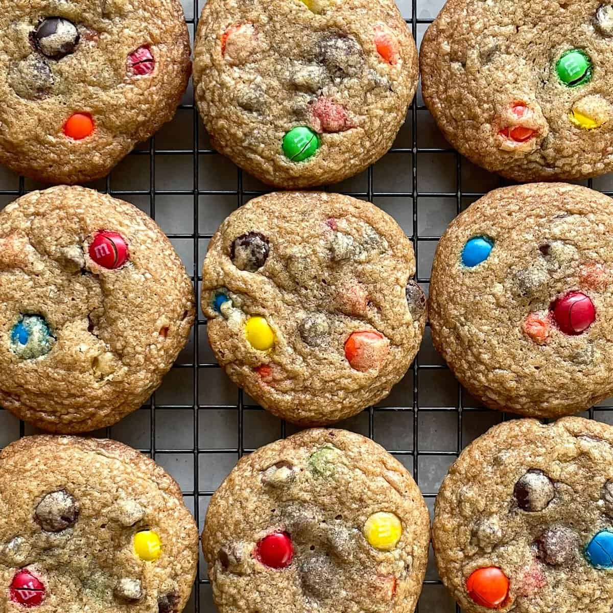 nine chocolate chip m and m cookies on a cooling rack.