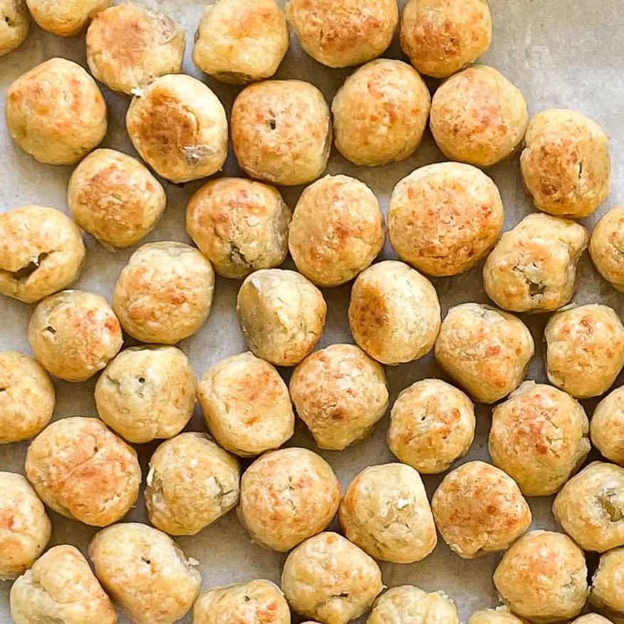 tray of baked green olives wrapped in cheese pie dough.