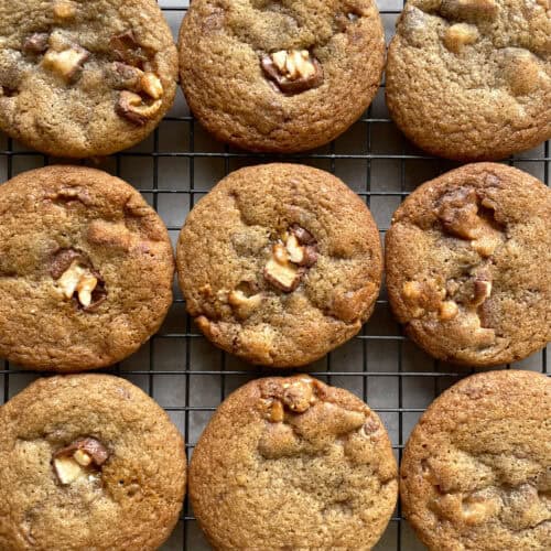 nine drop cookies with candy bar pieces on a cooling rack.