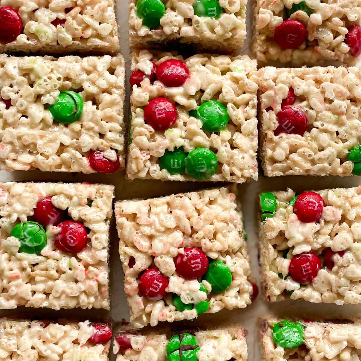 twelve rice krispie squares studded with red and green m and m candies.