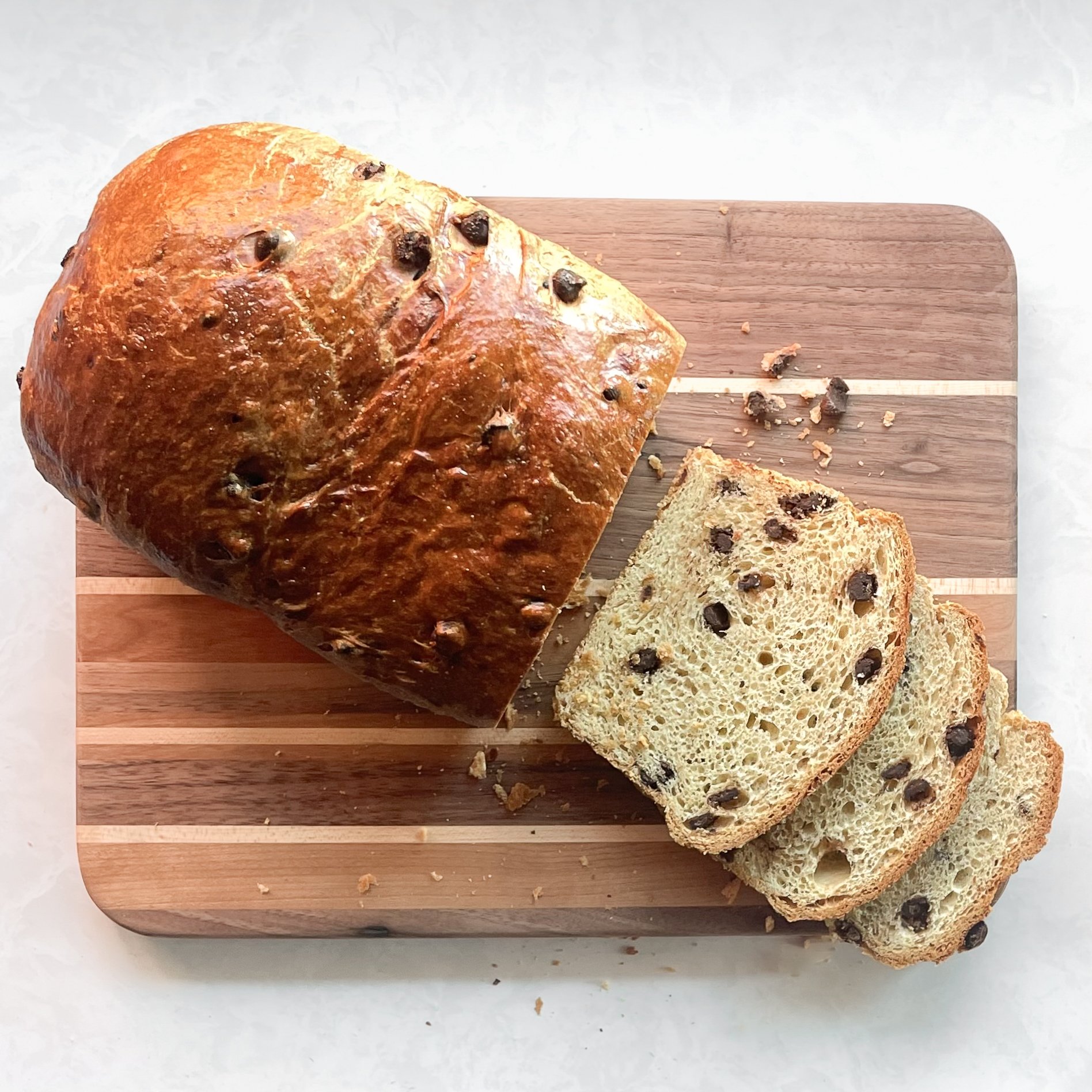 chocolate chip brioche loaf sliced on a wood cutting board.