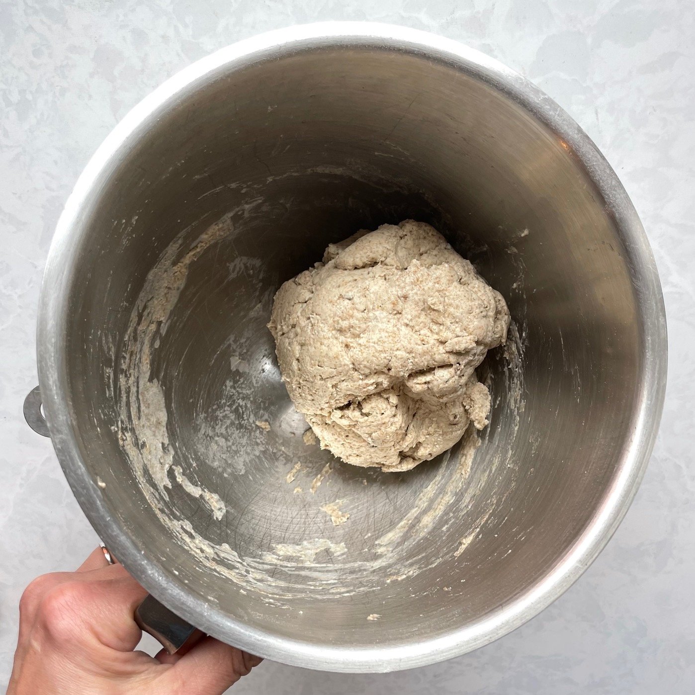rough ball of bread dough in a mixing bowl.