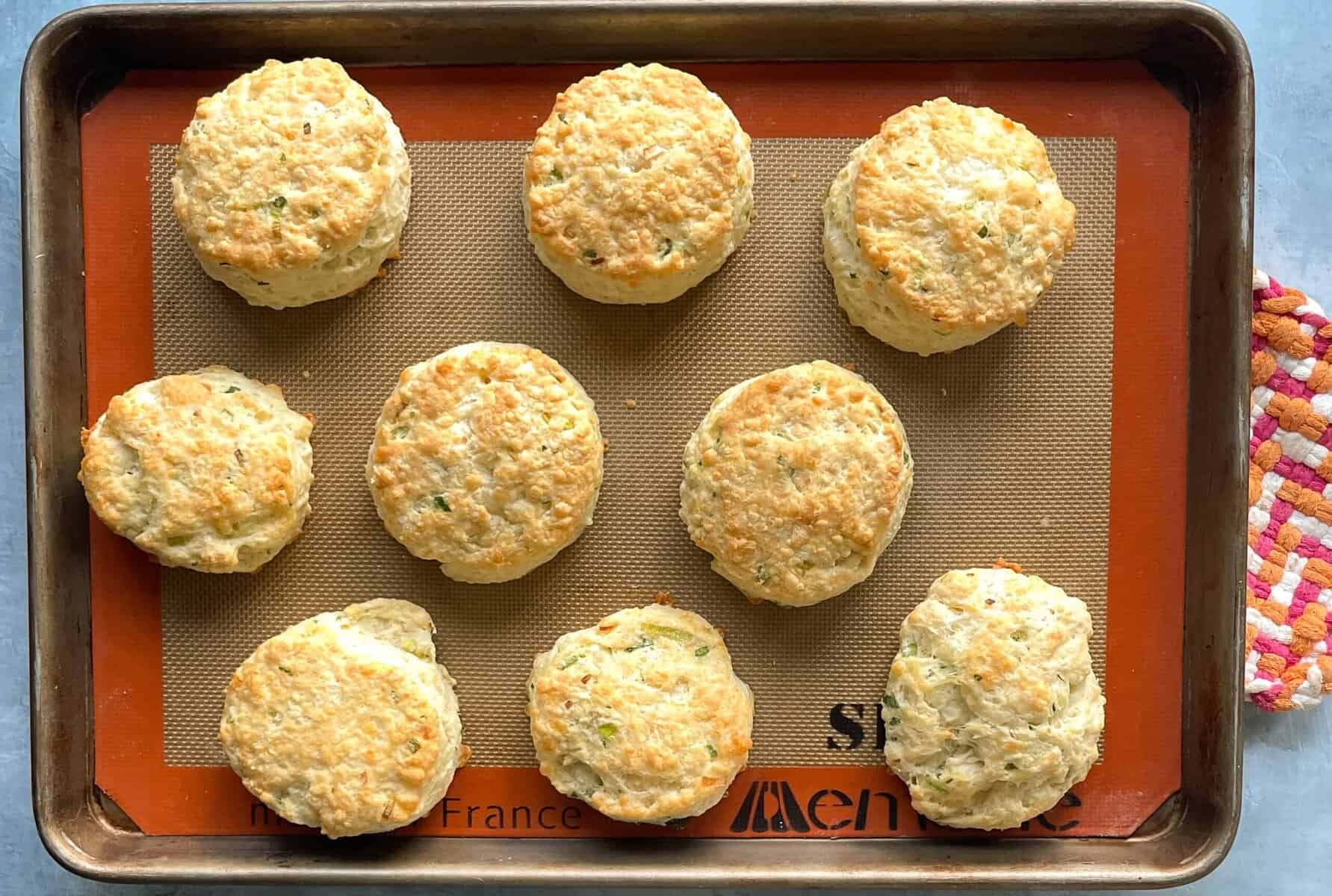 baked sourdough discard biscuits on a silicone lined baking sheet.