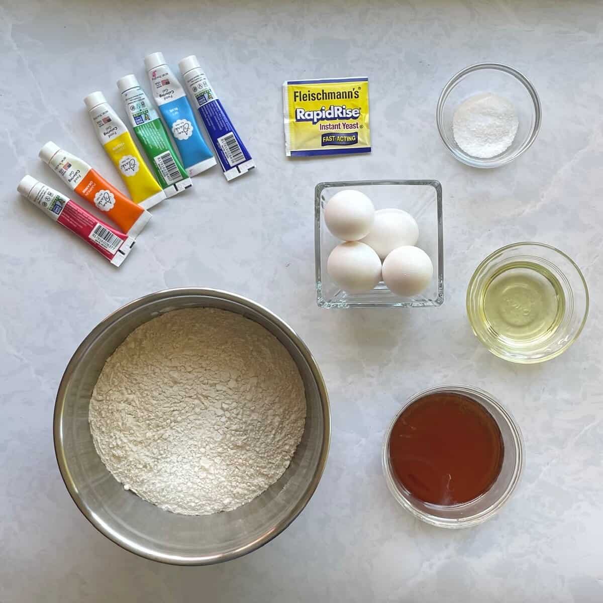 rainbow food coloring, flour, yeast, honey, eggs, oil, and salt.