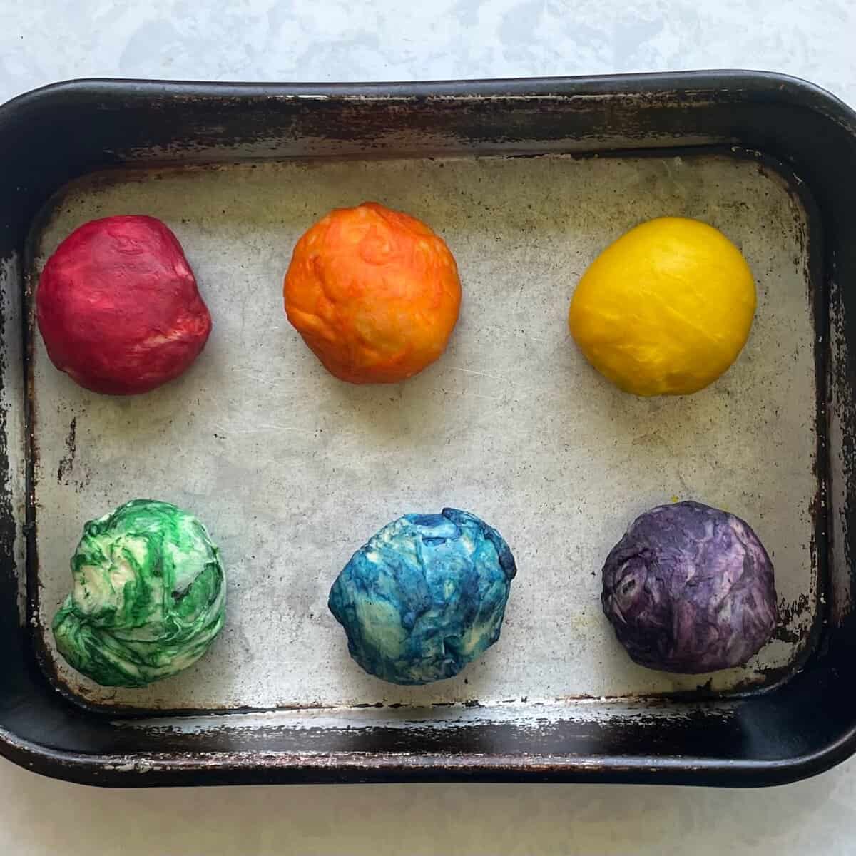 rainbow dough balls in a pan.