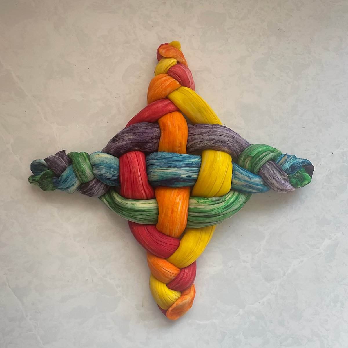step two in braiding the rainbow challah.