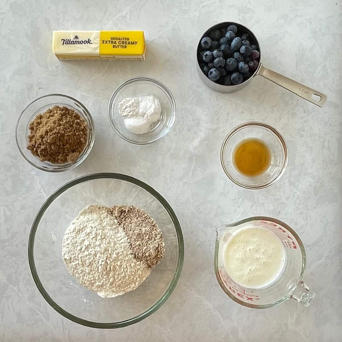 blueberries, butter, flours, brown sugar, vanilla, and baking powder in small bowls.