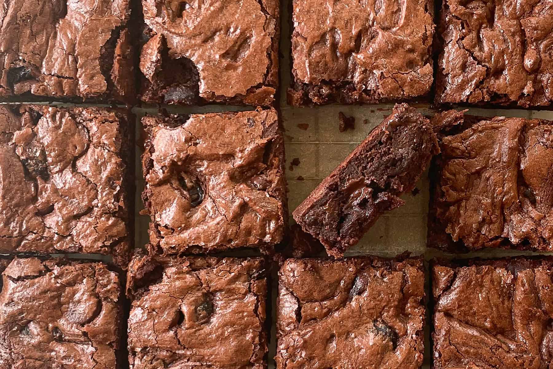twelve cut chocolate cherry brownie squares with one turned on its side.