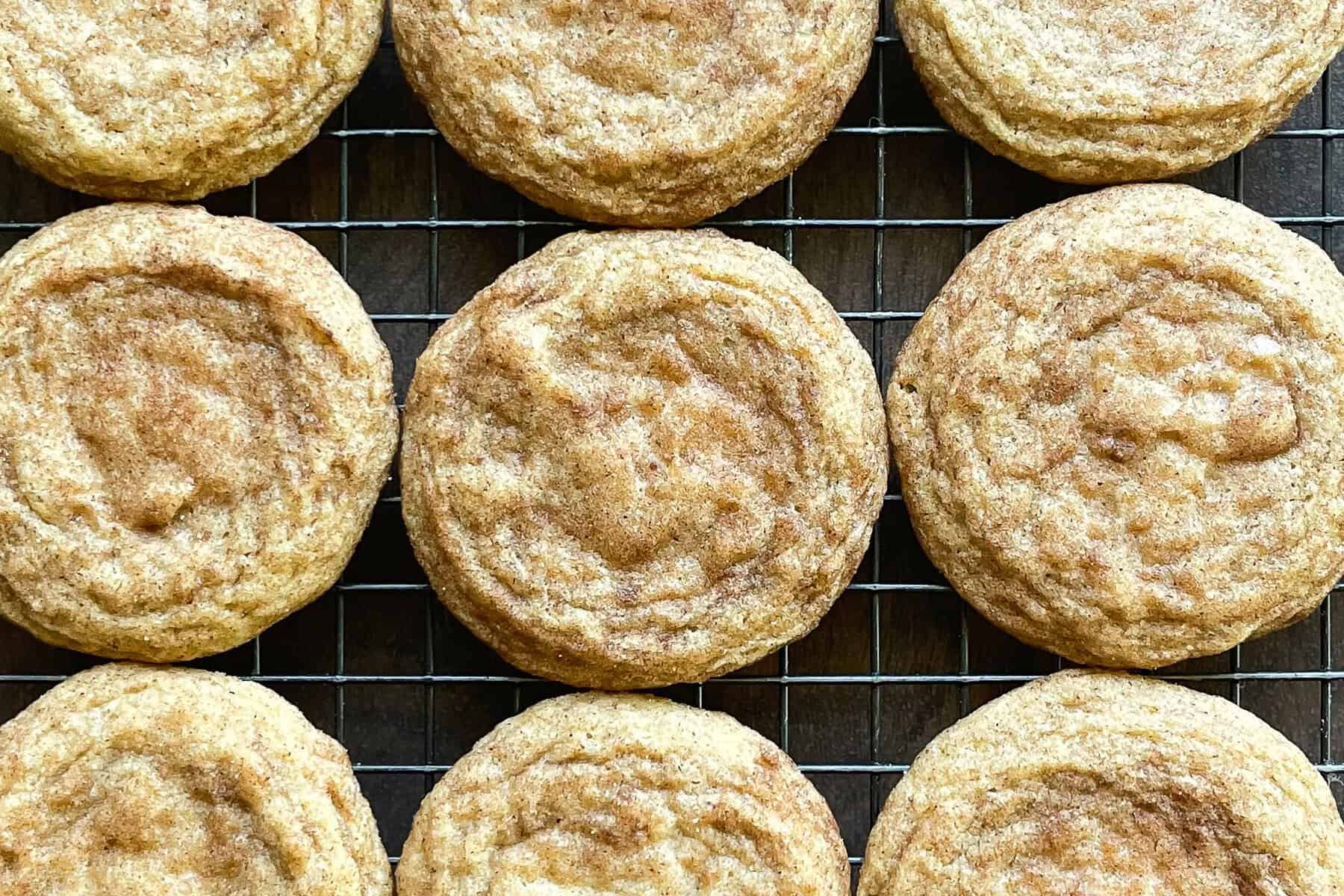 nine snickerdoodle cookies on a cooling rack.