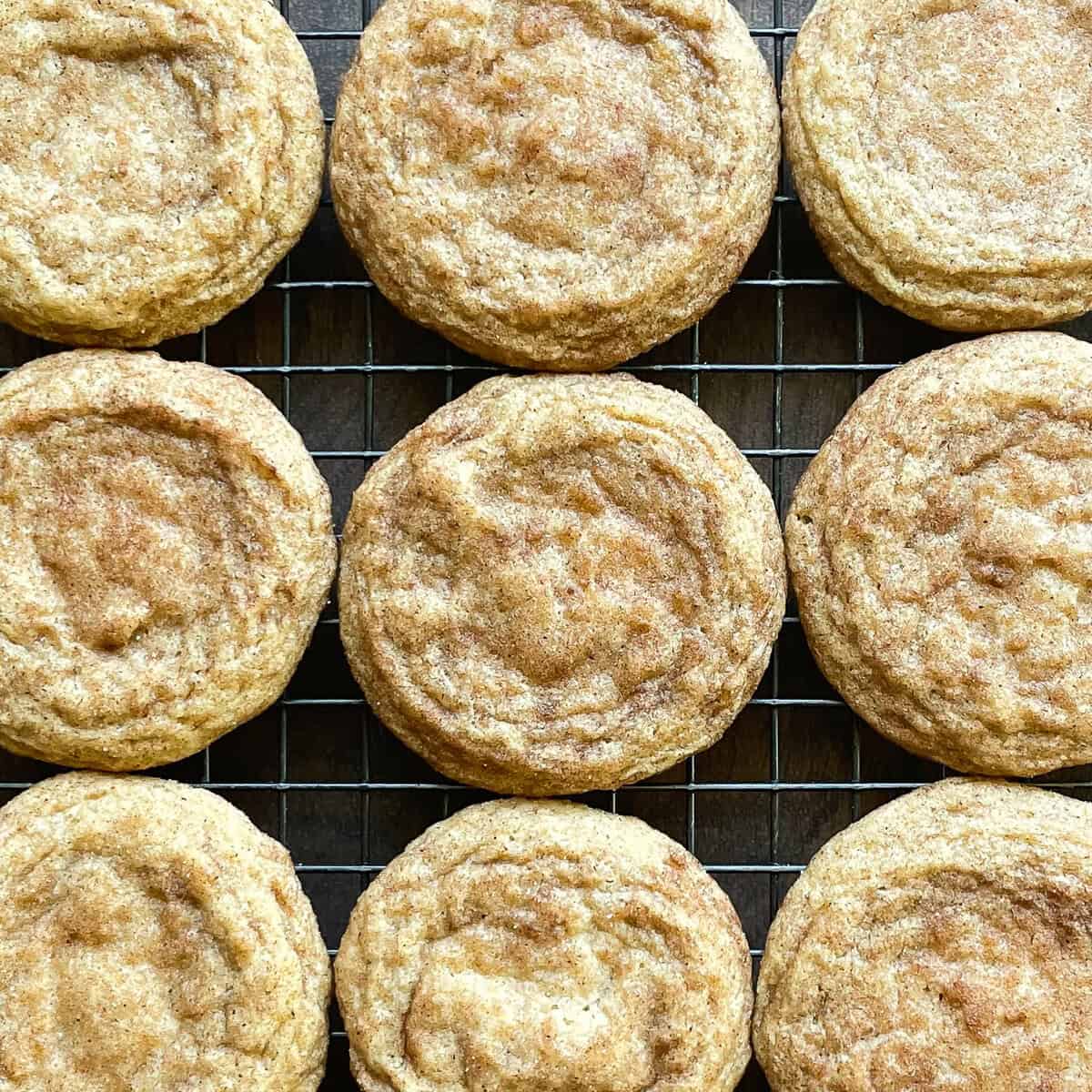 nine snickerdoodle cookies on a baking rack.