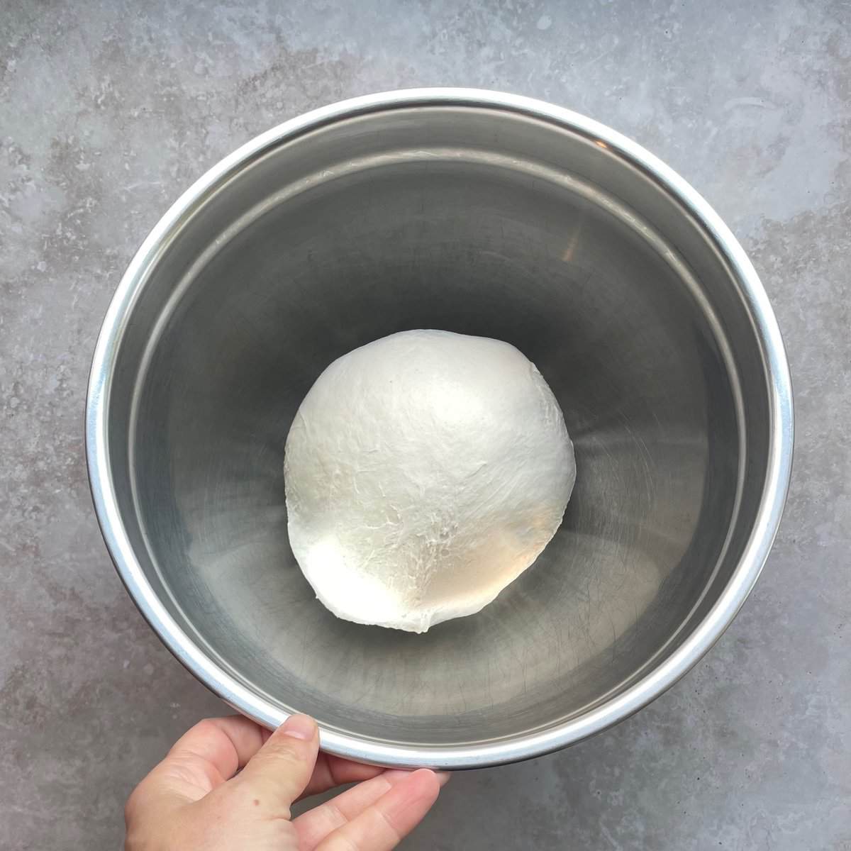 ball of pizza dough in a mixing bowl.