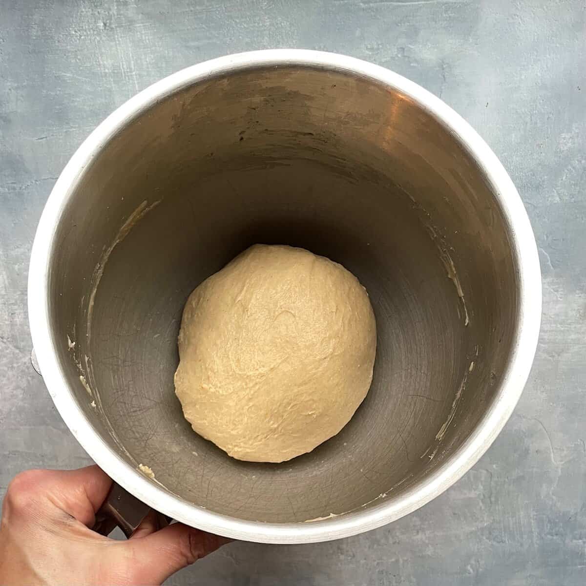 ball of cinnamon roll dough in a mixing bowl.
