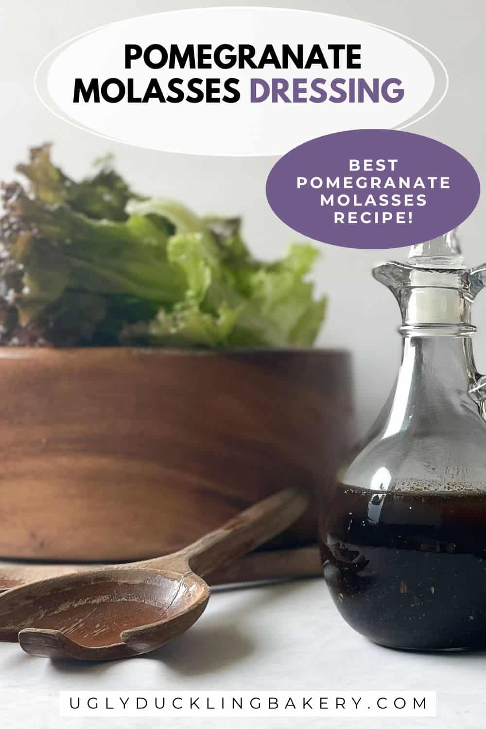 glass jar of dark salad dressing in front of wood salad bowl and tongs. The title says Pomegranate Salad Dressing. Best Pomegranate Molasses Recipe. The website ugly duckling bakery dot com is at the bottom.