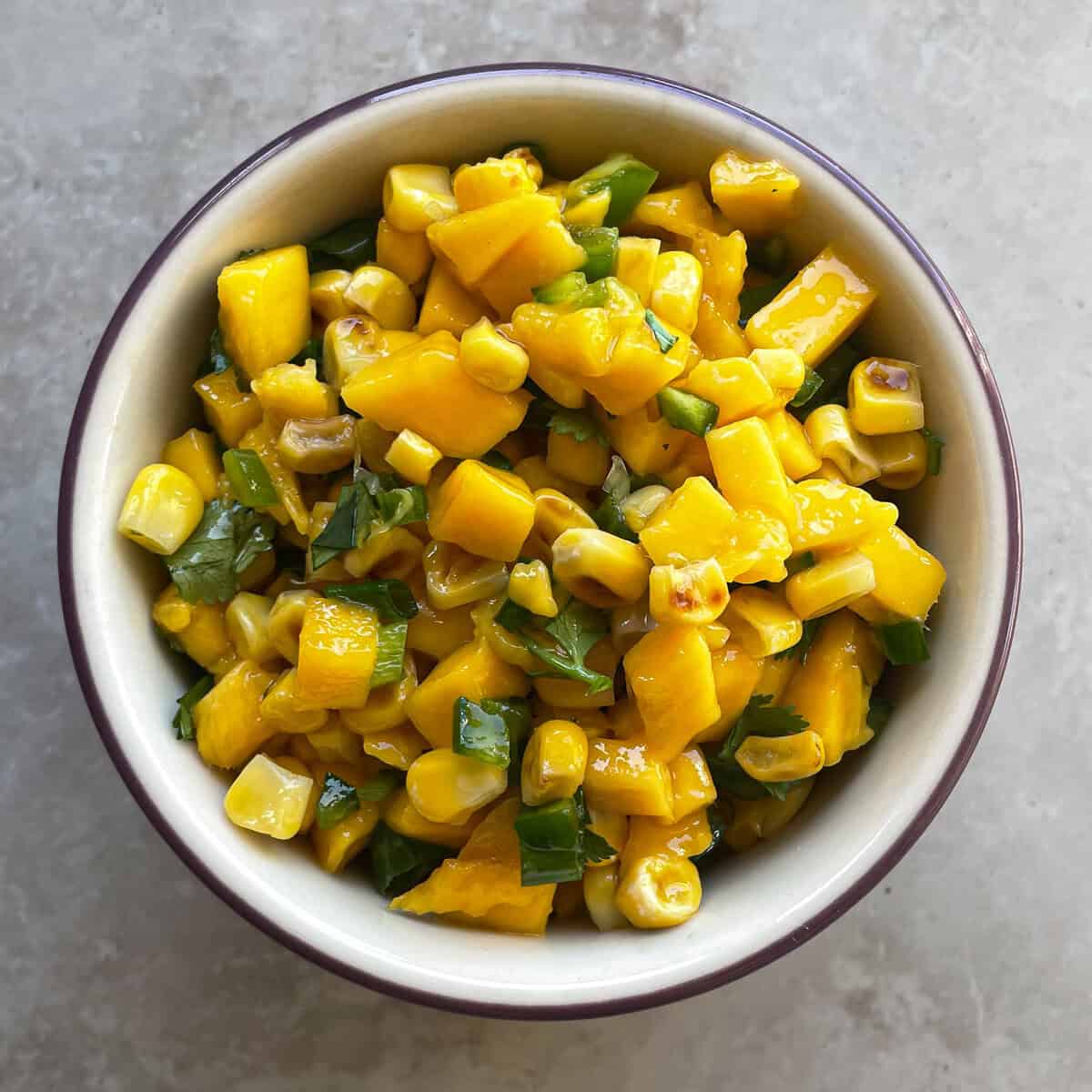 bowl of mango and corn salsa with green onion and jalapeno.