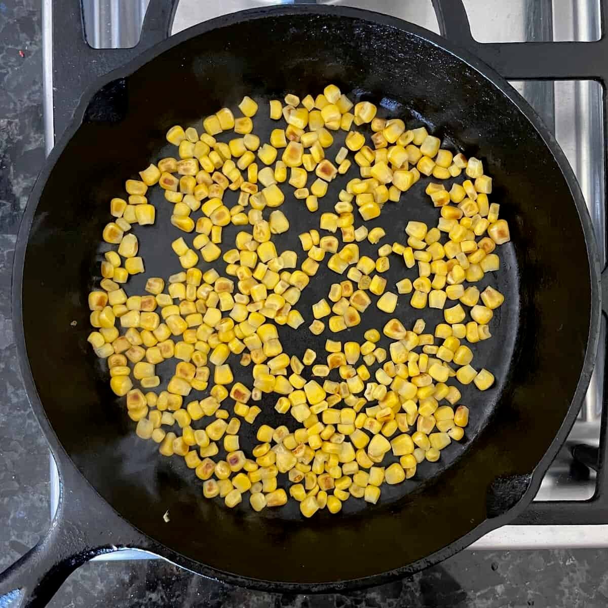lightly browned corn kernels in a cast iron skillet.