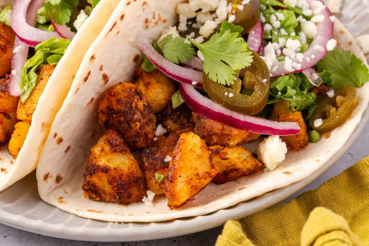 soft potato taco with spiced potato cubes, cotija, cilantro, red onion, and pickled jalapeno peppers.